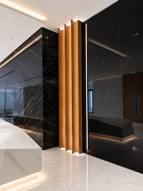 Lobby with black marble wall, timber fins and polished stone floor