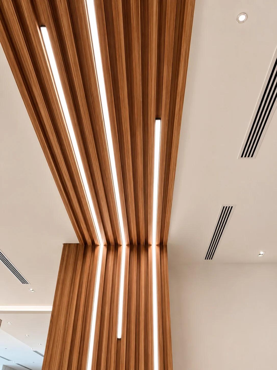 Curved timber slat ceiling with recessed linear lighting