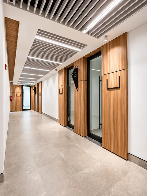 Corridor with timber ceiling panels and stone flooring