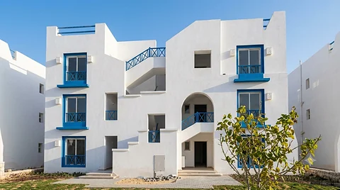 Residential block elevation with blue timber pergola on the roof terrace